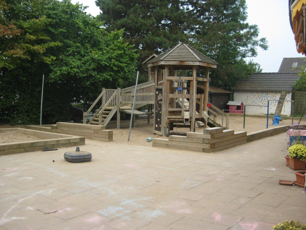 Montessori kindergarten Düsseldorf outdoor playground with wooden climbing structure and sand area for active play