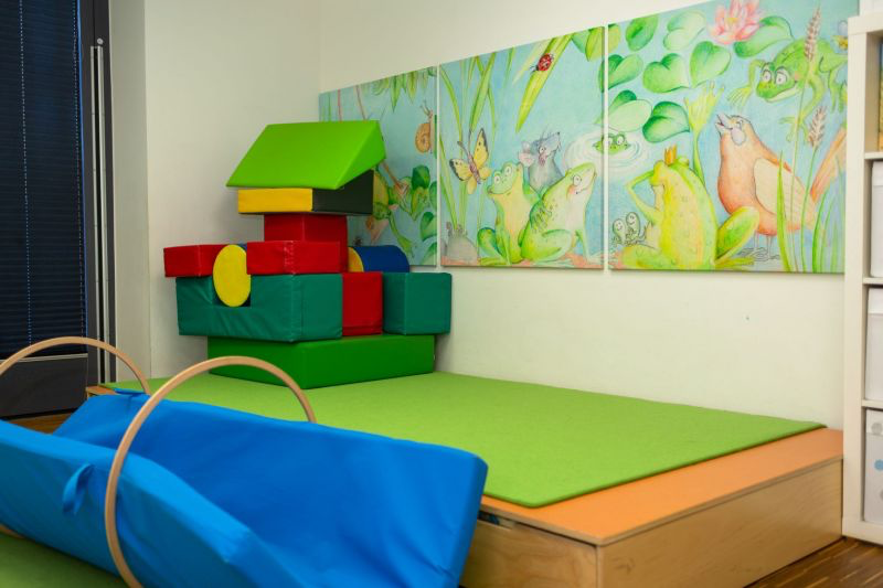 kindergarten's soft play area with colorful foam blocks and nature-themed wall art