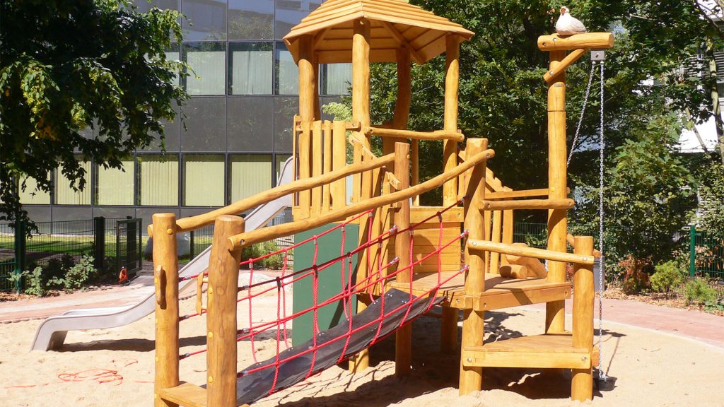 outdoor play structure with wooden climbing frame, slide, and sand area for active learning