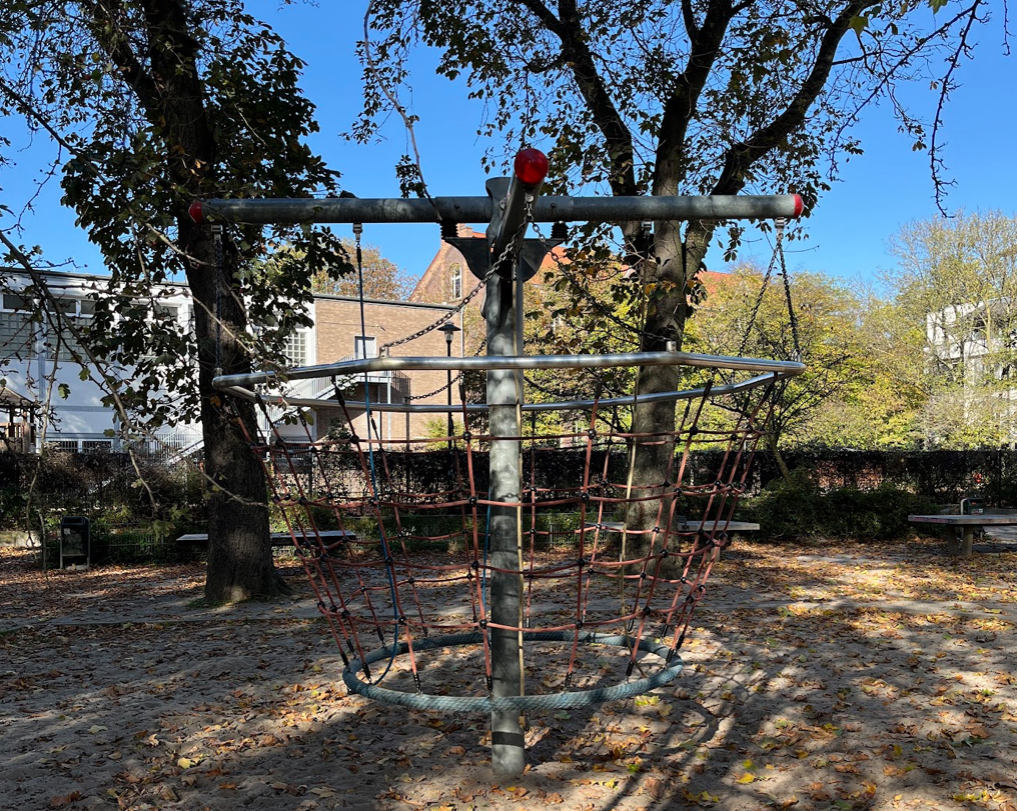 Leo-Stadt Platz – Rope climbing basket in a shaded outdoor playground in Düsseldorf during autumn