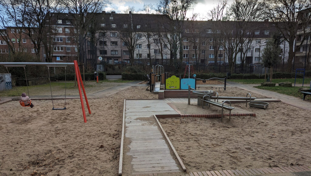 Playground Engerstraße – Quiet outdoor playground in Düsseldorf with swings, a small climbing area, and sand play structures