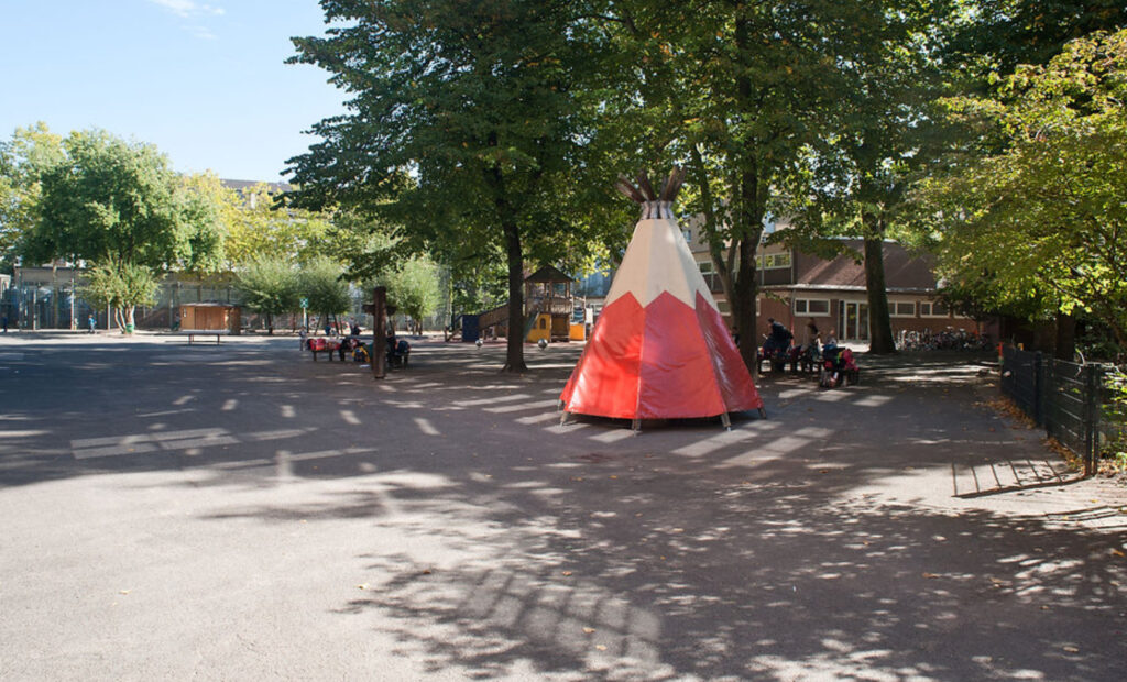 Outdoor play area at a Montessori school in Düsseldorf with a tipi structure
