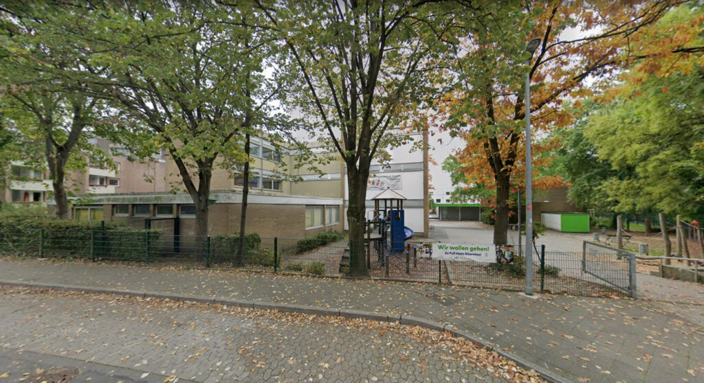 Front gate of Städtische Gemeinschaftsgrundschule Erkrath with trees in autumn
