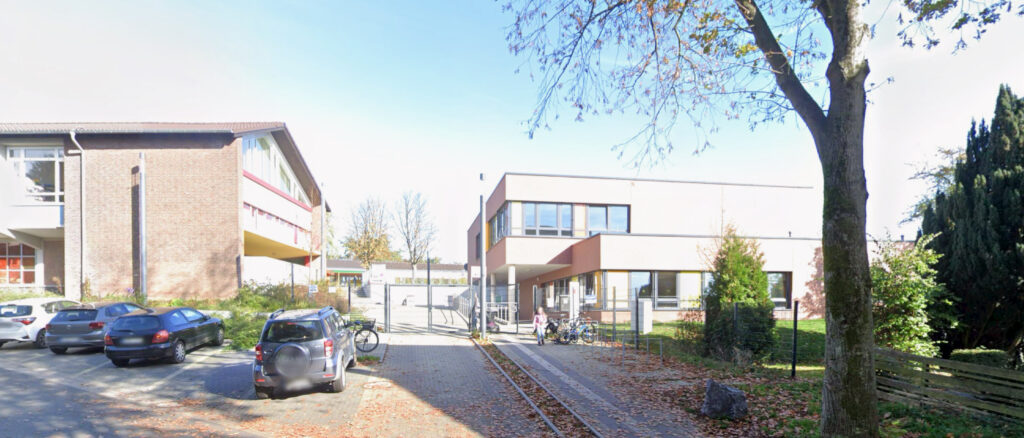 Wichernschule entrance at sunset surrounded by trees and shrubs
