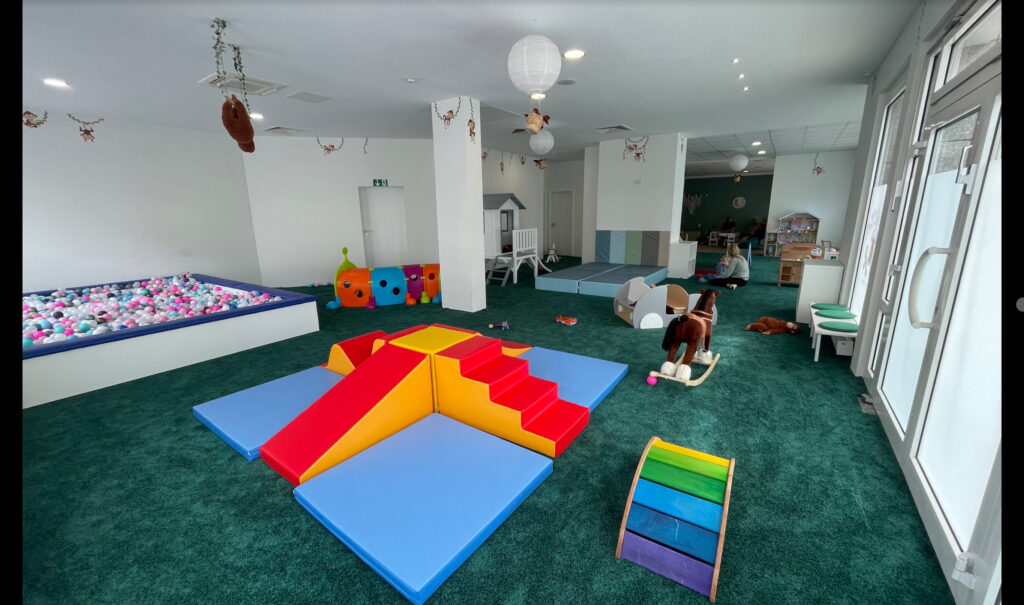 Soft play area with climbing mats, ball pit, and toddler-friendly toys in a child-focused space