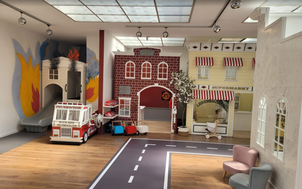 Miniature indoor city play area for kids with fire station, supermarket, and roleplay buildings designed for imaginative learning