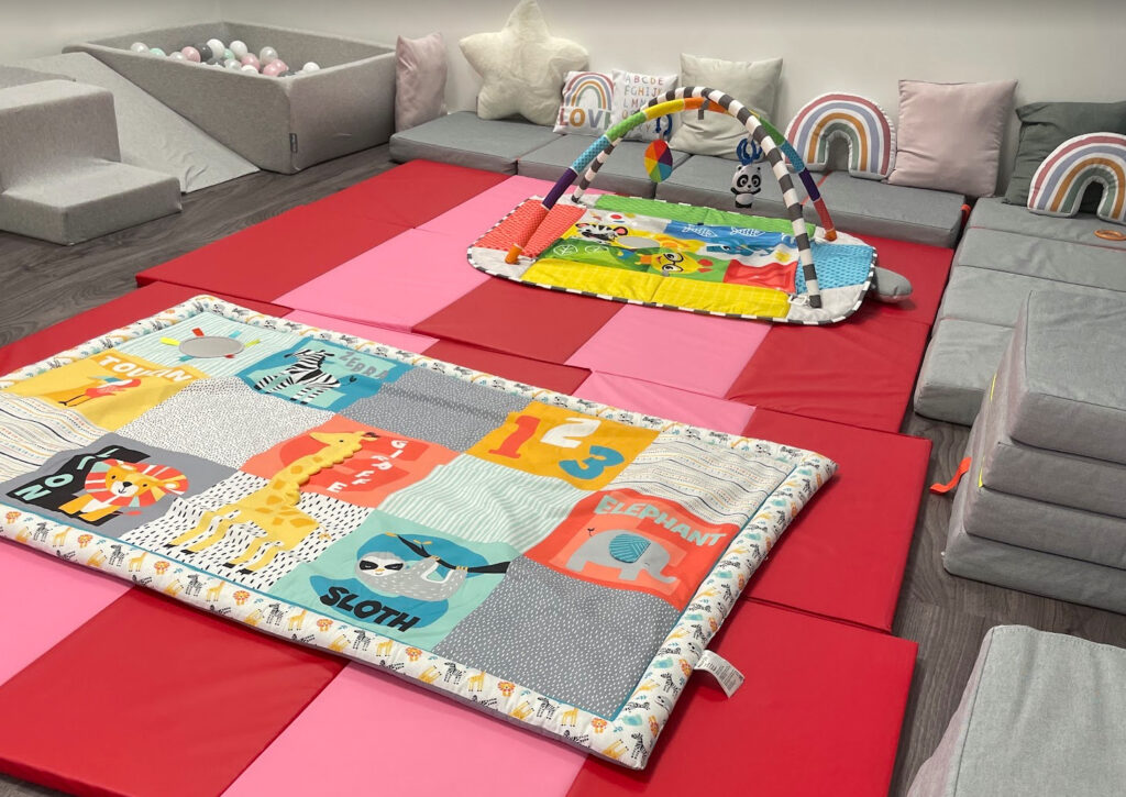 Soft play area with padded mats and baby sensory toys designed for infant development and tummy time activities