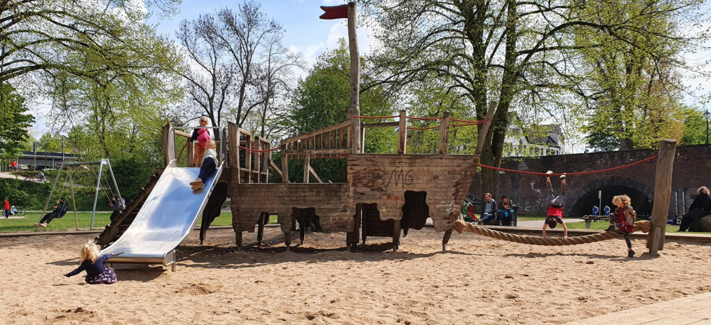 Spielplatz Kaiserswerther Markt – Pirate ship playground structure with slide and rope bridge at an outdoor playground in Düsseldorf