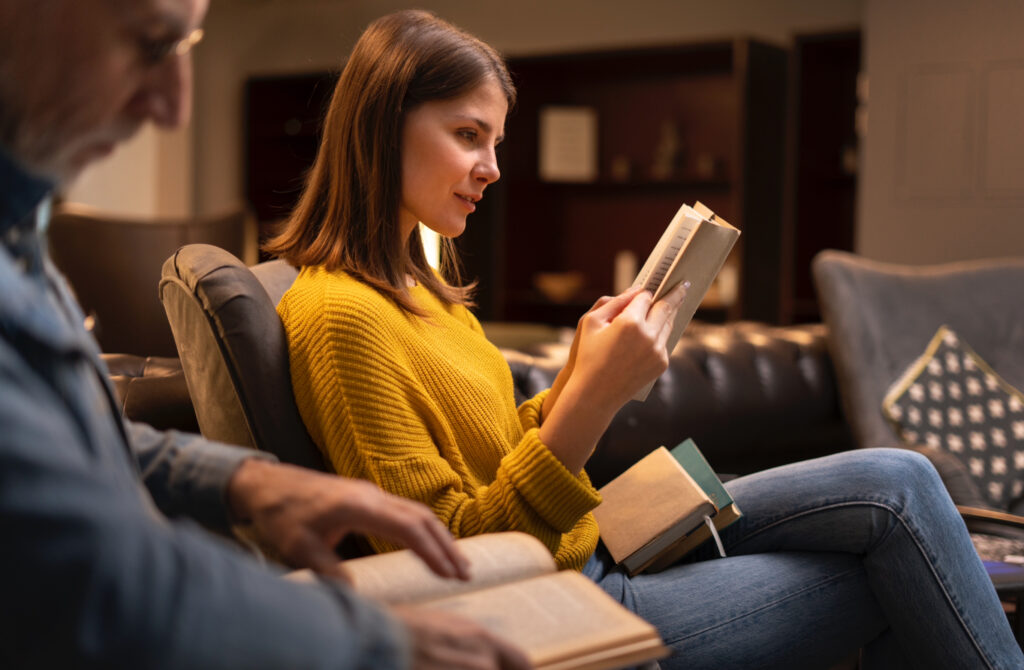 Two adults reading Montessori parenting books together at home