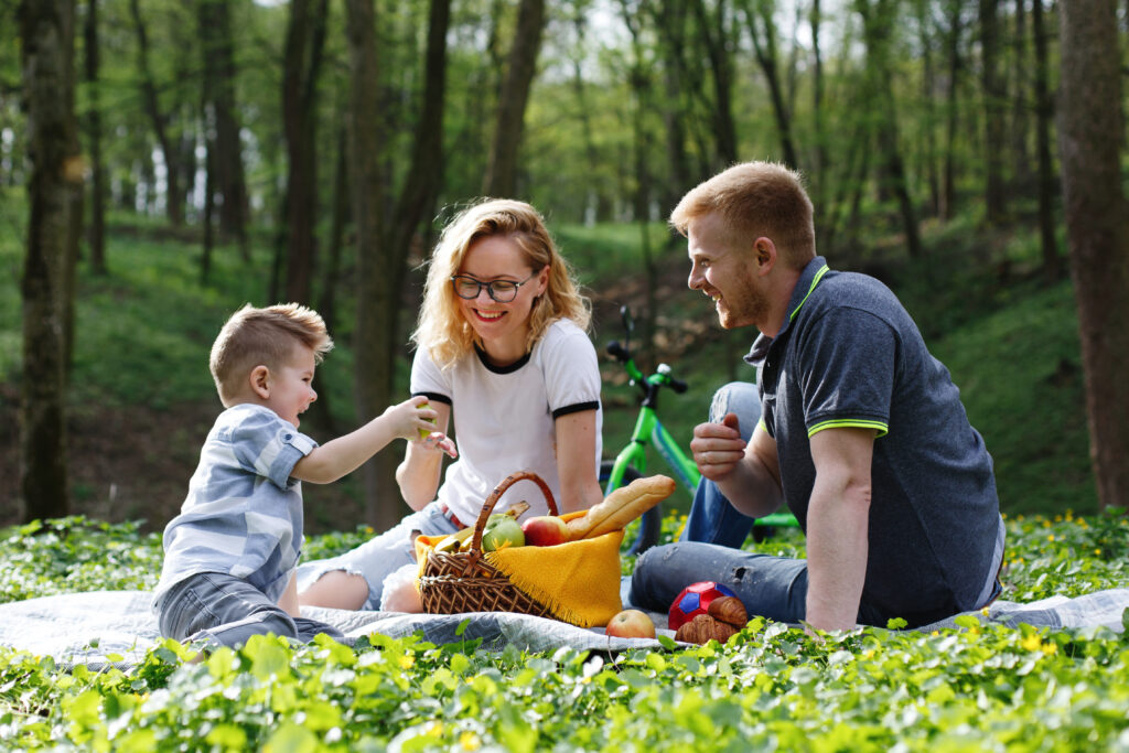 a family of three enjoying a sunny day in a park 