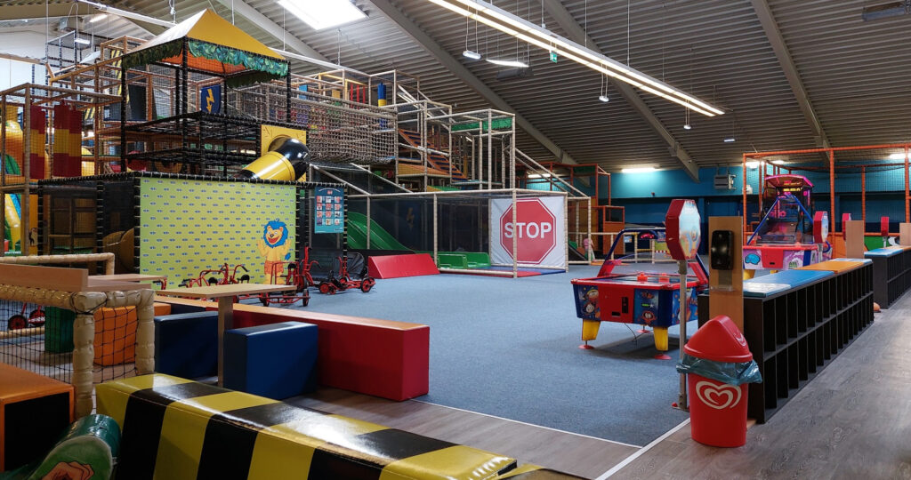 Indoor activities for children in NRW including climbing structures, mini traffic course, arcade games, and creative play zones