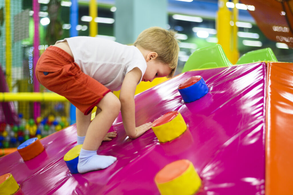 Child climbing in an indoor playground as a Kindergarten Düsseldorf alternative

