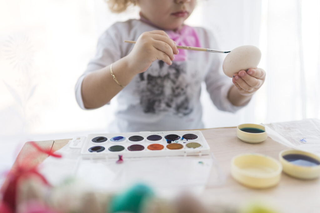 Child painting during creative early learning and preschool activities
