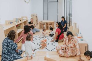 Montessori classroom setup with multi-age students engaged in self-directed work with teachers and tutors