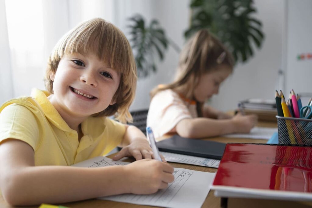 an image showing English lessons for kids in Düsseldorf with two children learning English in a cozy classroom
