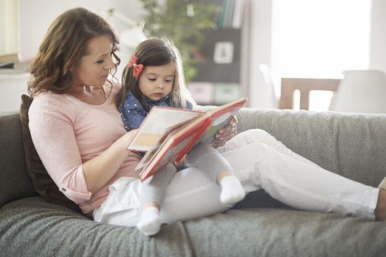 Parent reading a picture book with a young child at home, supporting early literacy through shared reading and language bonding
