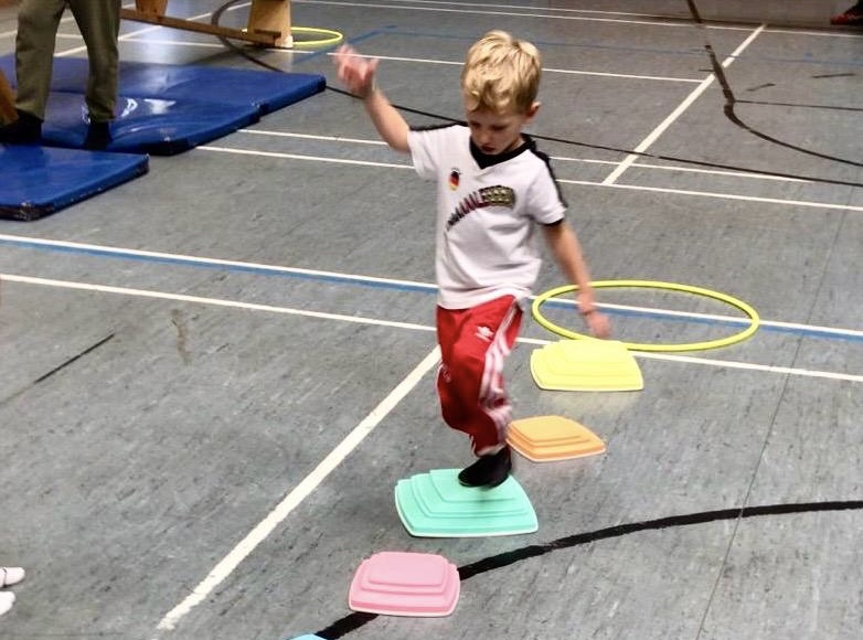 child reaching upward in gymnastics training for kids near me, building strength