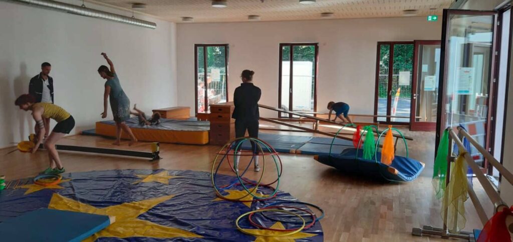 gymnastics for kids in Düsseldorf class with instructor guiding children on balance beam