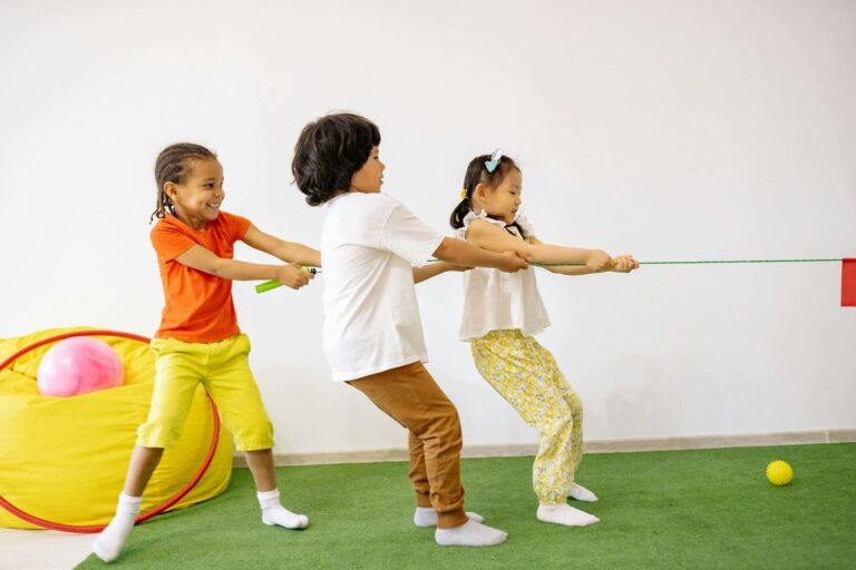 Children playing tug-of-war during a gymnastics class for kids in Düsseldorf, developing teamwork and motor skills through fun indoor activities