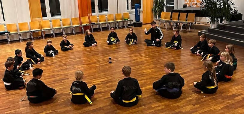 children sitting in circle during a lesson at Sascha de Vries Karate Fachsportschule – Karate school for Young Kids in Düsseldorf