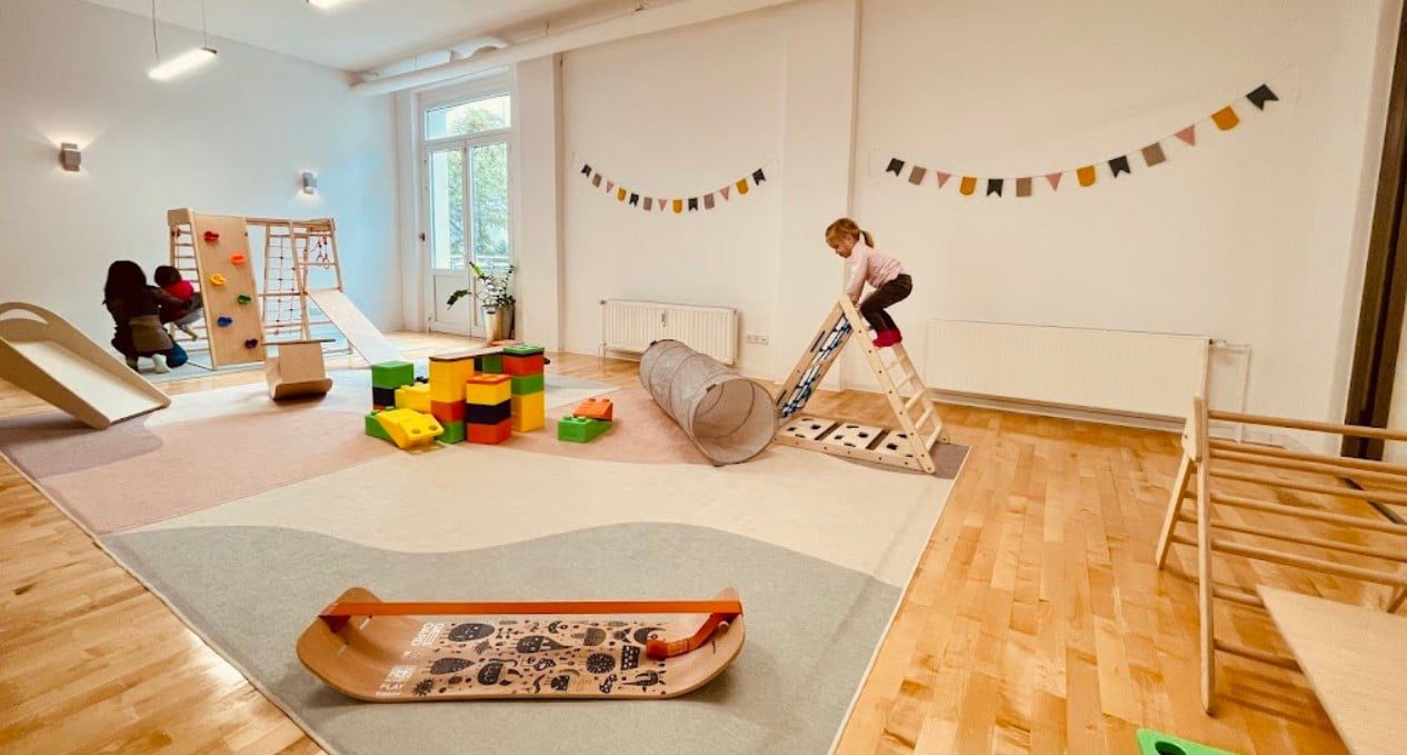 Spacious indoor area designed for gymnastics for kids with climbing frames, blocks, and balance tunnels

