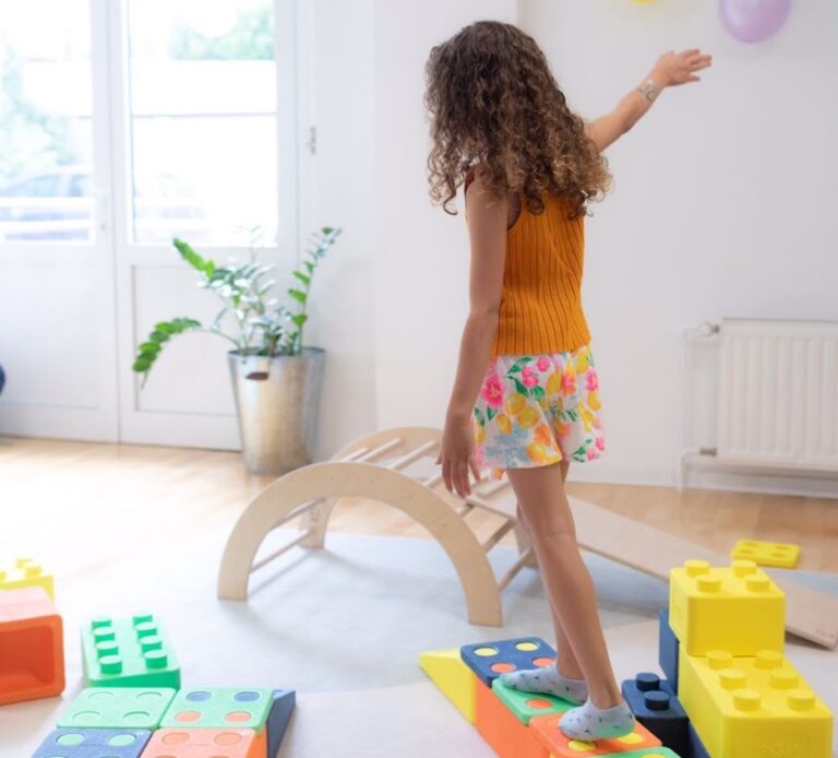Young girl practicing balance and coordination on foam stepping stones in a children's motor skills class