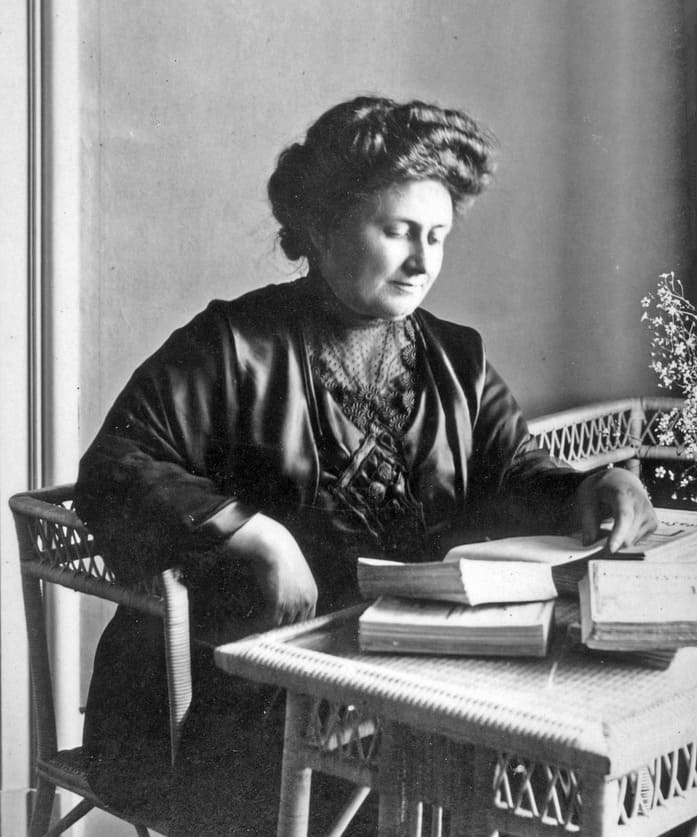 Dr. Maria Montessori studying educational materials — founder of the Montessori philosophy and pioneer in child-centered education.


