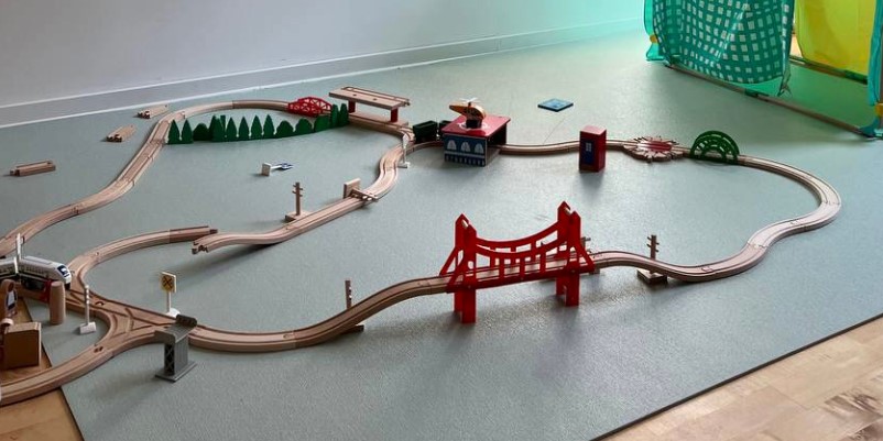 Illustrative image for the Toys vs touchscreens guide:  Open-ended play environment with wooden train tracks promoting imaginative learning beyond electronic devices