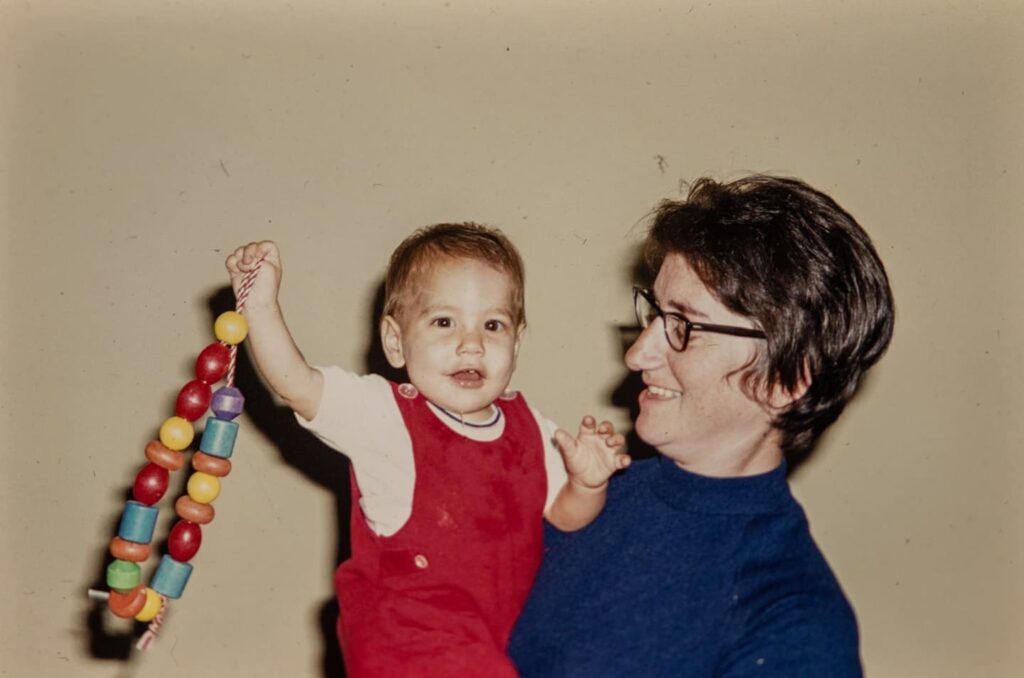 Infant exploring colorful objects with a parent, engaging in sensory experiences that support early Montessori math development