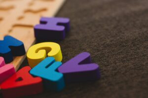 Colorful Montessori moveable alphabet letters used to support early writing skills before reading fluency, illustrating hands-on phonetic learning in literacy education.

