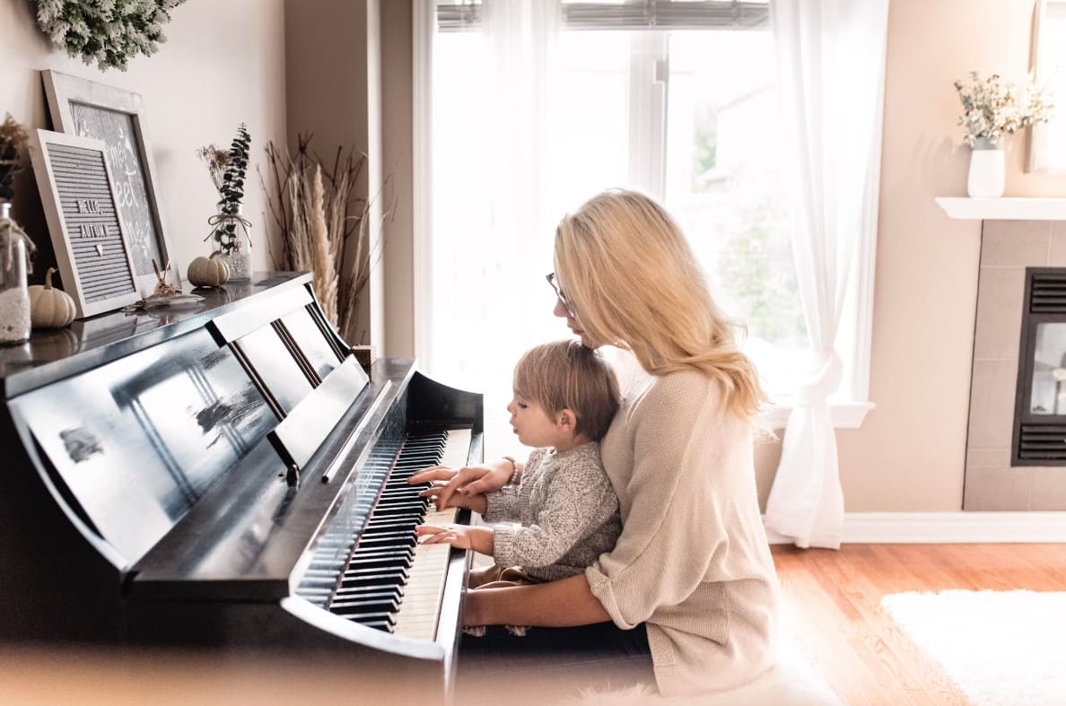 Montessori music at home – parent-child piano activity fostering emotional connection, auditory discrimination, and music appreciation.