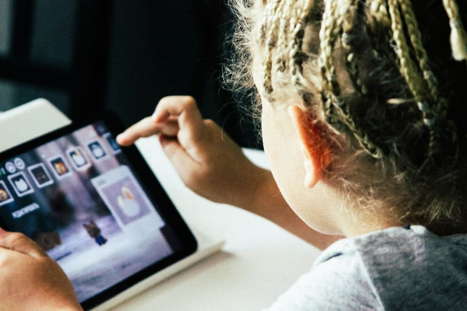  girl using an AI-powered educational app on a tablet, reflecting the integration of Montessori AI tools into child-led digital learning experiences.