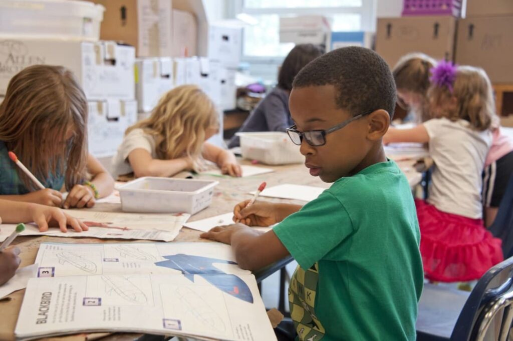 Group of children studying in a traditional classroom setting — comparing Montessori vs. traditional schools for ADHD children.
