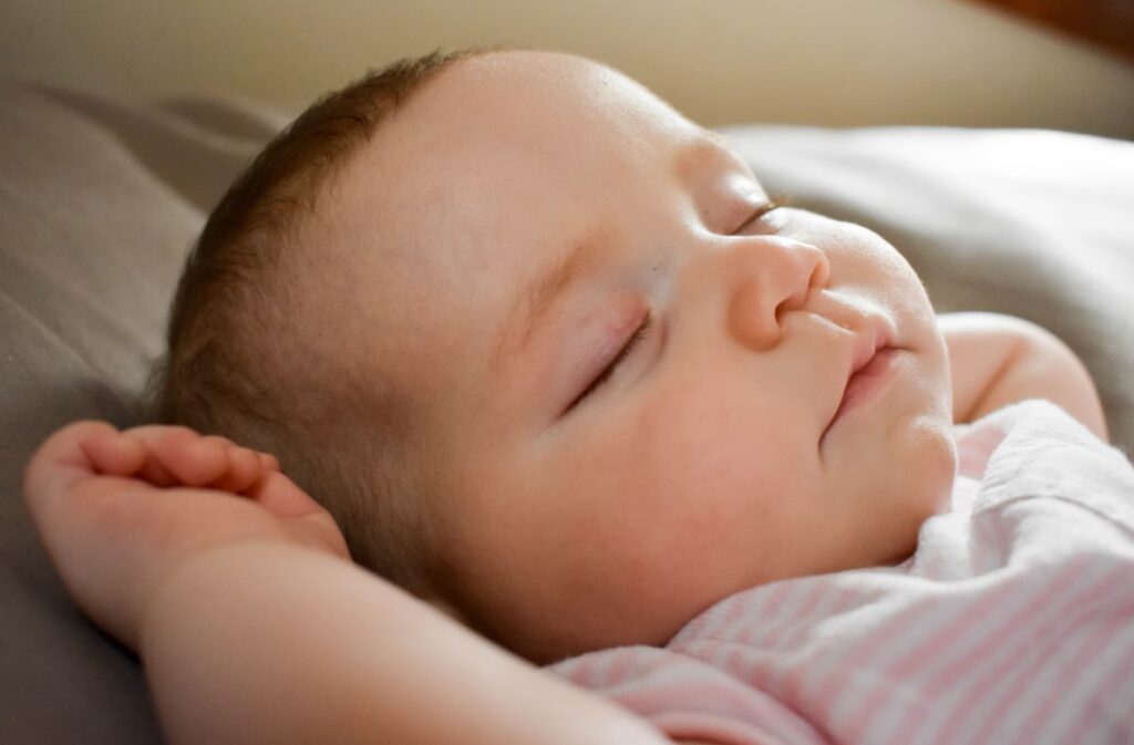 Peacefully sleeping baby demonstrating the benefits of a Montessori floor bed in supporting restful and independent sleep