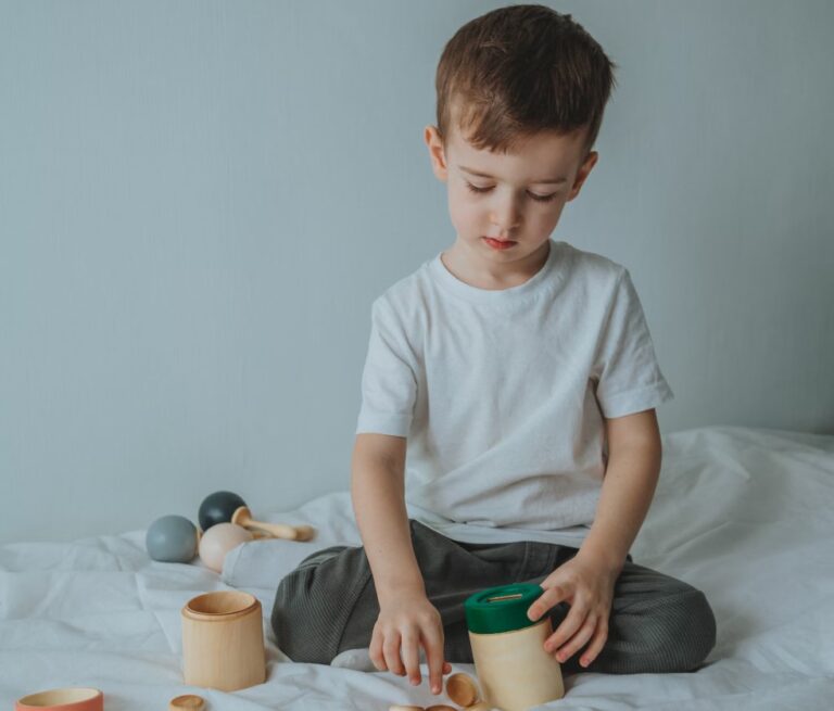 A young boy exploring hands-on learning tools at home, demonstrating the benefits of Montessori education through independent play