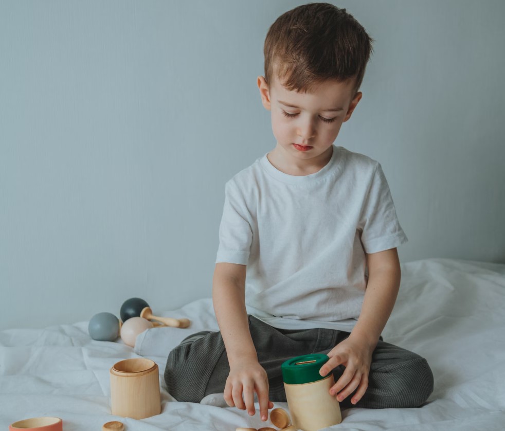 A young boy exploring hands-on learning tools at home, demonstrating the benefits of Montessori education through independent play
