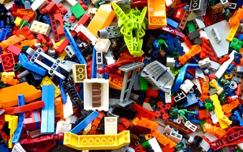 chaotic pile of colorful plastic building blocks illustrating toy overload and visual clutter in a non-Montessori play space