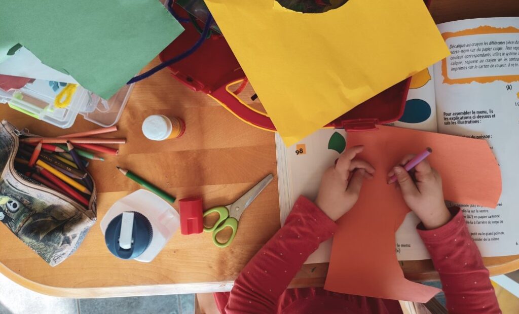 A child engaged in a colorful art and craft activity, representing sensory-based learning and practical life skills in Montessori education for neurodiverse learners.