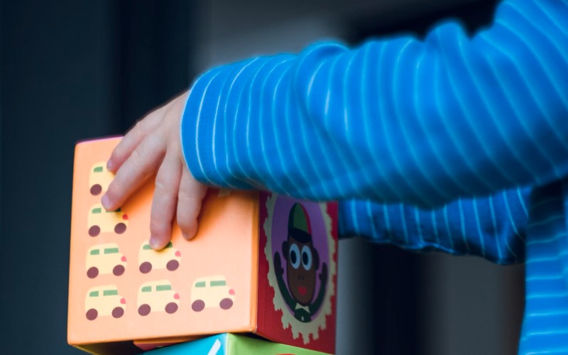 Baby practicing fine motor skills with Montessori-style developmental toys