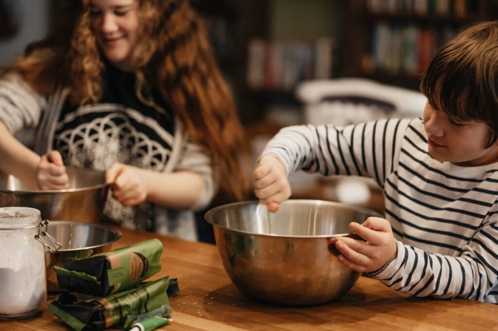 Children mixing ingredients in a Montessori kitchen, practicing real cooking skills and building confidence through hands-on culinary activities.