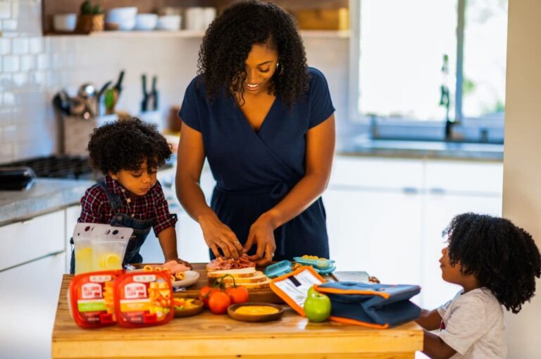 Mother practicing Montessori parenting tips while preparing food with her children in the kitchen, encouraging independence and learning through daily routines.