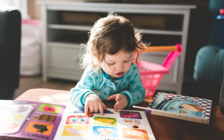 toddler exploring books independently in a calm, well-organized Montessori toddler room designed to promote early literacy and self-guided discovery