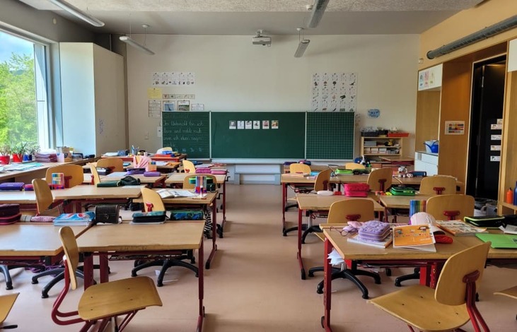 Typical German classroom setup with empty desks and green chalkboard — illustrating the structure of the school system in Germany.

