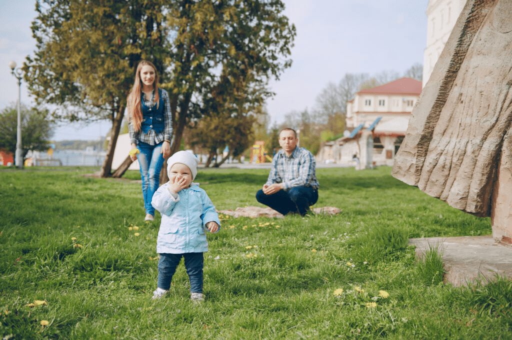 A toddler playing in a city park while parents watch — family moments and outdoor play options for young children in Düsseldorf.