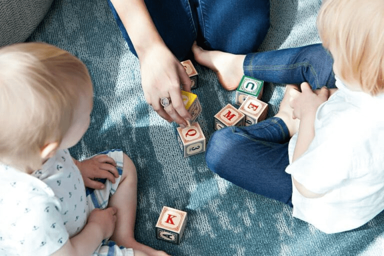 children playing with wooden cubes with letters
