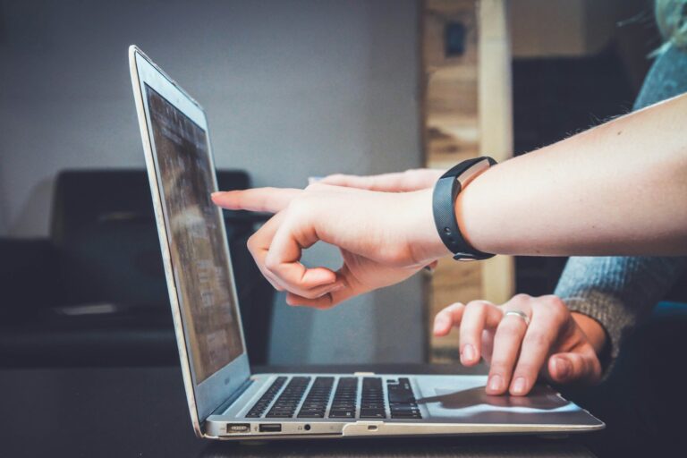 cover image for the Ultimate Montessori FAQ with people working by a laptop pointing to the screen