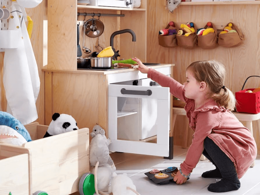 a girl with a child-size kitchen
