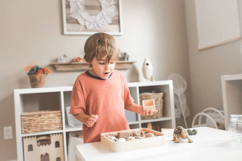 A young child engaged in independent work in a bilingual Montessori environment, exploring hands-on materials that support language development through play, focus, and self-directed learning.