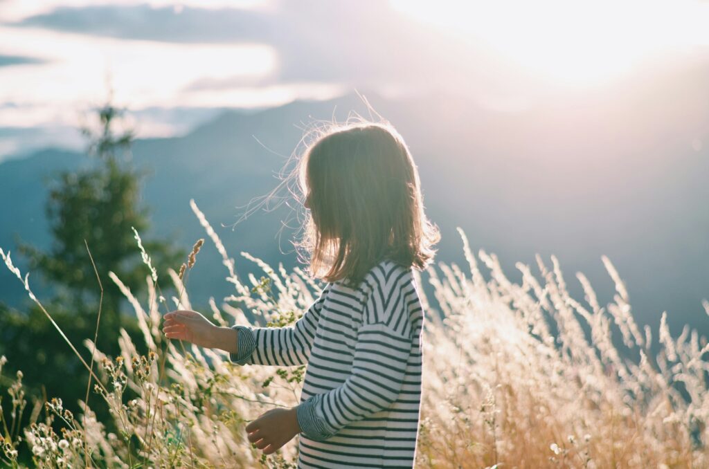 A child immersed in a natural landscape, developing emotional regulation, awareness, and a sense of connection through direct contact with nature.